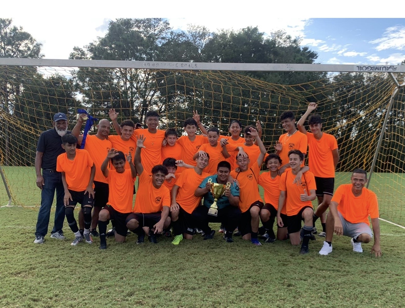 Wolves squad celebrating with trophy in front of the goal