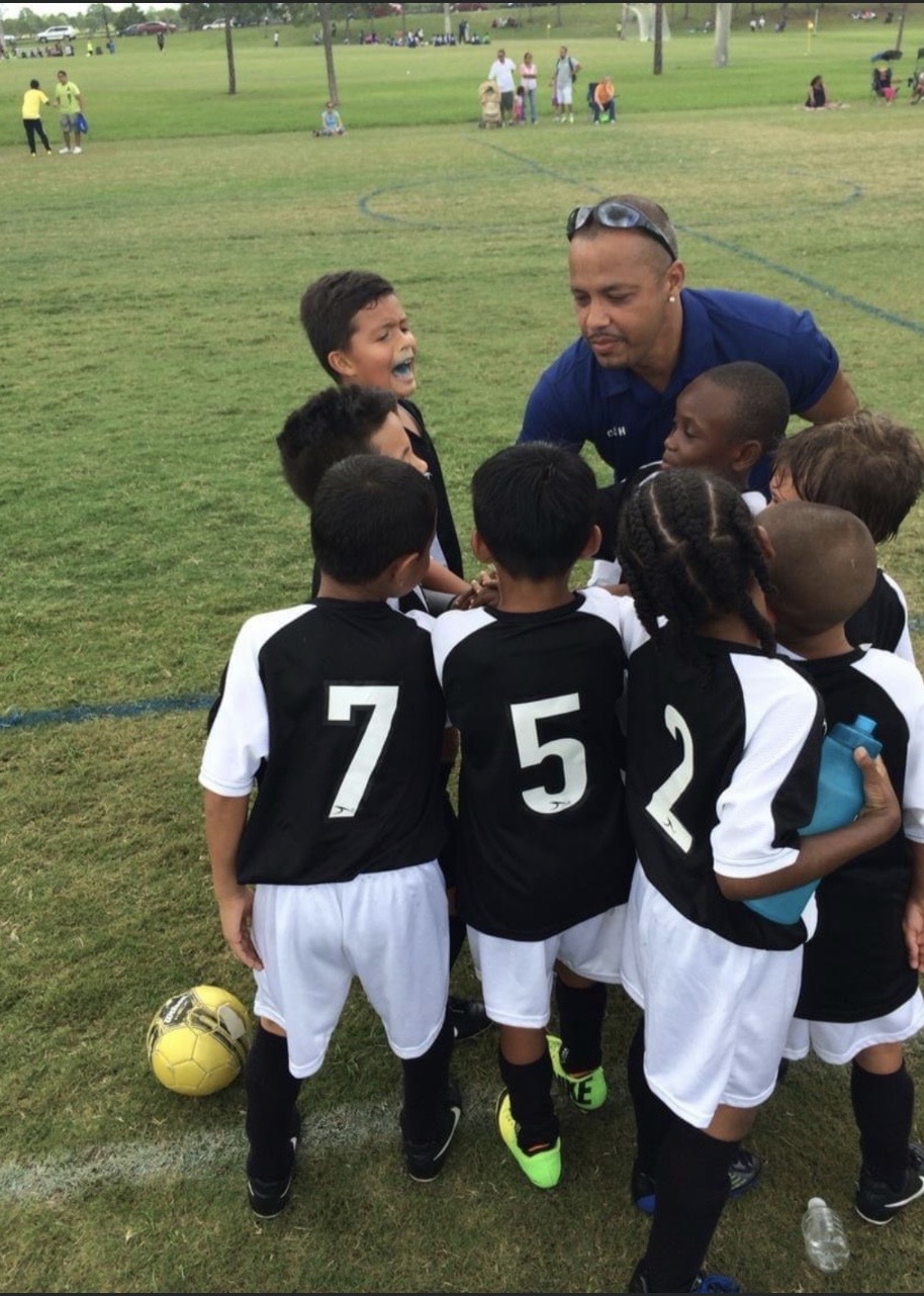 Young Wolves huddle with coach before kickoff