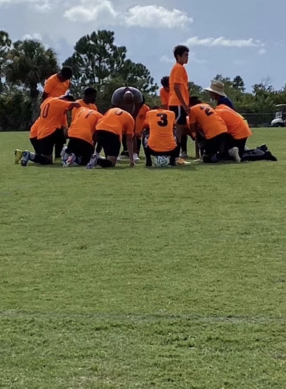 Team kneeling in pre-match huddle
